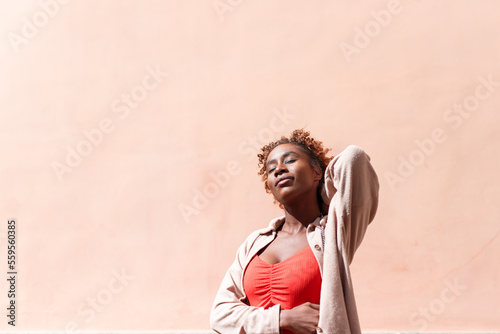 Young Afro woman posing on level background © jorge