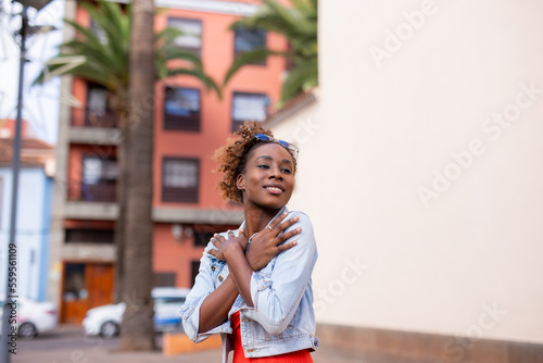 Happy Afro woman posing on street