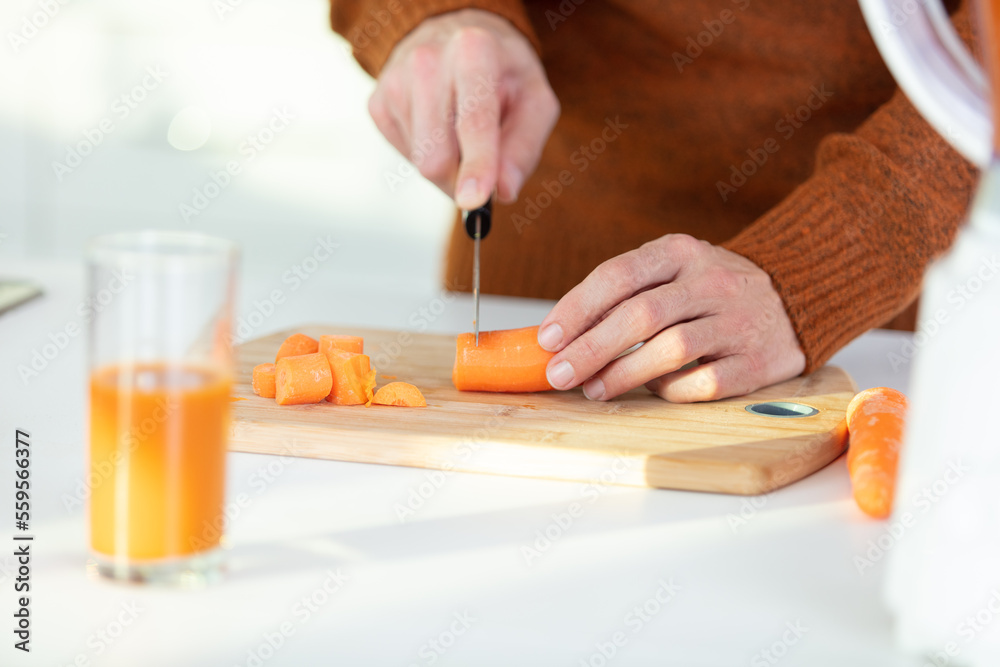 cropped image of carrot being chopped for juice cropped image of carrot being chopped for juice