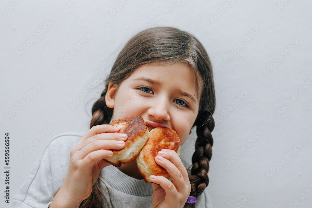 little caucasian girl with appetite eats fried pies, fast food, junk food, flour little caucasian girl with appetite eats fried pies, fast food, junk food, flour