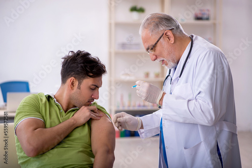 Young male patient visiting old male doctor in vaccination conce