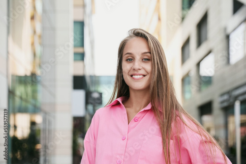 Beautiful young woman in stylish shirt on city street