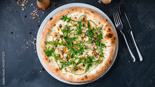 Fresh pizza with pear slices, gorgonzola cheese, walnut and arugula.