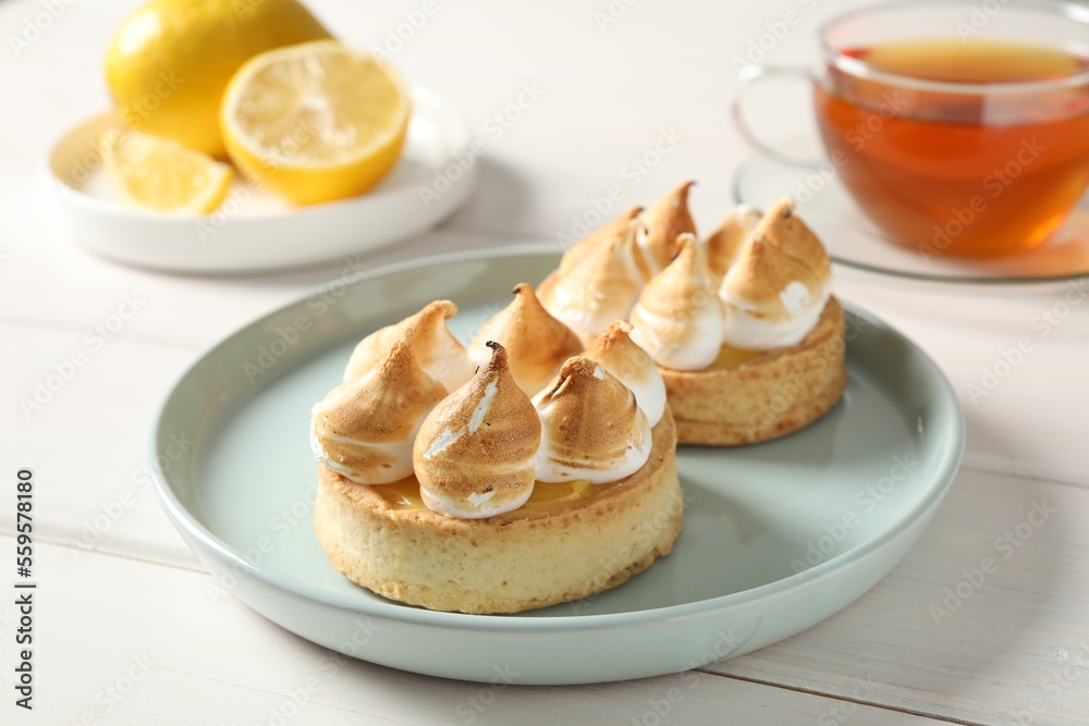 Delicious lemon meringue pies on white wooden table Delicious lemon meringue pies on white wooden table