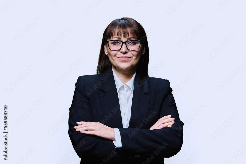 Confident middle aged business woman in jacket on light background