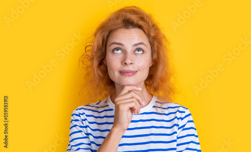thinking redhead girl face isolated on yellow background. face of young redhead girl in studio.