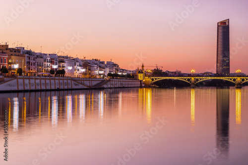 Sunset over the authentic neighborhood of Tirana in Seville with views on Calle Betis  Torre Sevilla and with awesome reflections in the river Guadalquivir  creating magic atmosphere and views
