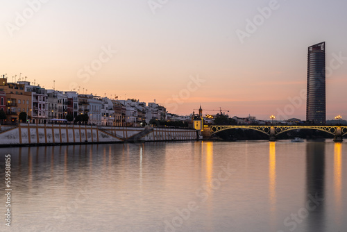 Sunset over the authentic neighborhood of Tirana in Seville with views on Calle Betis  Torre Sevilla and with awesome reflections in the river Guadalquivir  creating magic atmosphere and views