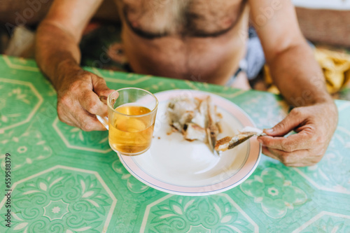 Adult man drinks beer and eats dry fish while sitting in a bar in summer. Food photography.