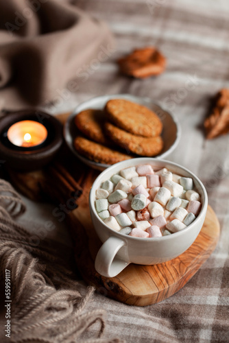 warm cozy bedroom winter or autumn concept, cup of hot chocolate on tray, candles throw