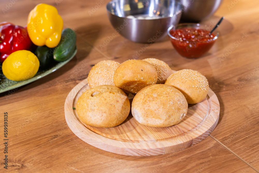 Freshly baked burger buns with sesame seeds in kitchen Freshly baked burger buns with sesame seeds in kitchen
