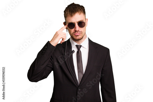 Security bodyguard man wearing a suit isolated cut out showing a disappointment gesture with forefinger. © Asier