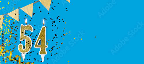 Golden candle number fifty four. Birthday or anniversary card with the inscription 54 on blue background. Anniversary celebration. Banner. photo