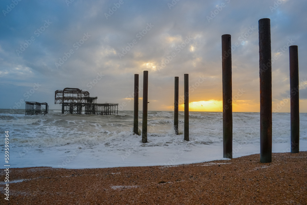 Burnt out Brighton Pier during a storm and sunset