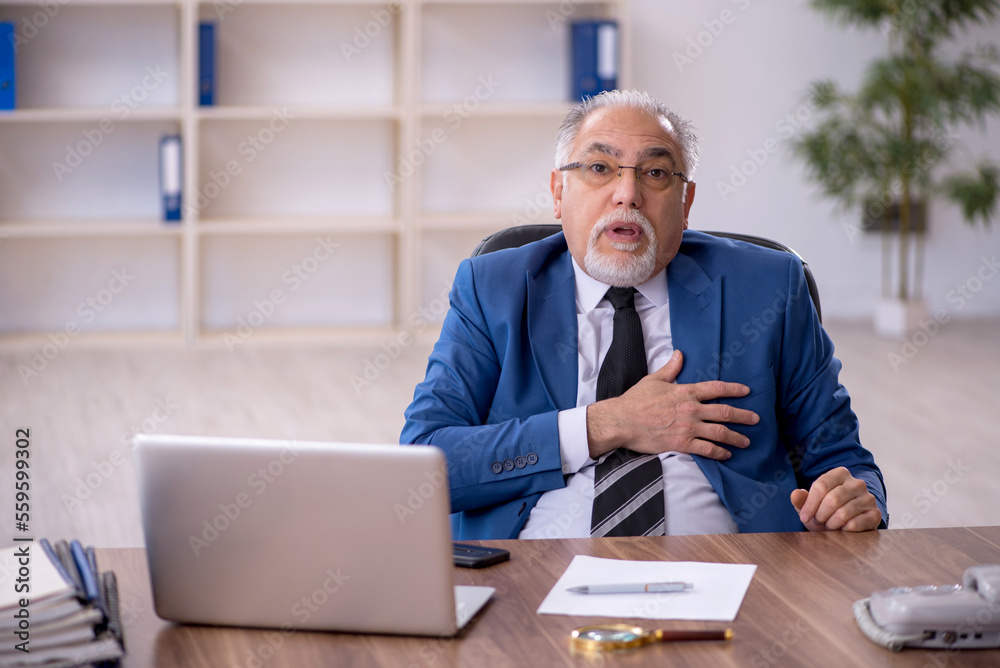 Old male employee working in the office Old male employee working in the office