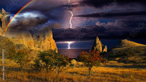 Thunderstorm and rainbow over the Black Sea, Crimea. Lightning flashes and a rainbow shines over the Black Sea coast, Eastern rocky Crimea, near Feodosia and Koktebel. 