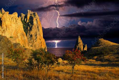 Thunderstorm and rainbow over the Black Sea, Crimea. Lightning flashes and a rainbow shines over the Black Sea coast, Eastern rocky Crimea, near Feodosia and Koktebel. 