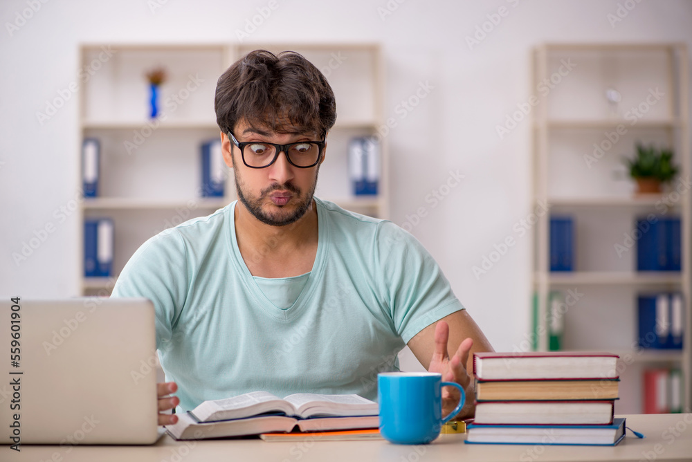 Young male student preparing for exams in the classroom Young male student preparing for exams in the classroom