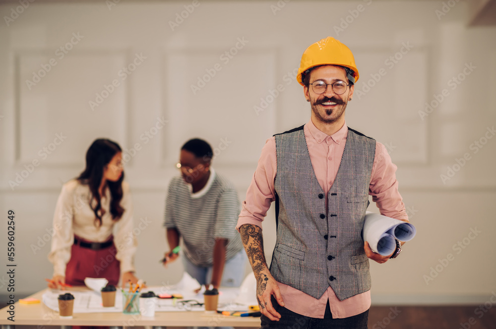 Male architect using blueprint and tablet in an office during a meeting Male architect using blueprint and tablet in an office during a meeting