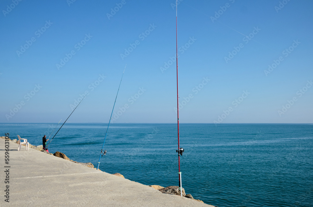 Fishing rods on the pier.
Fishing rods ready to catch fish and have a good time.
