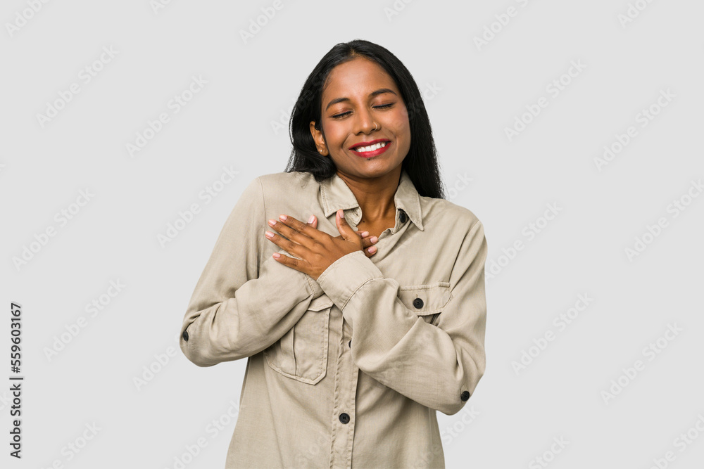 Young Indian woman cut out isolated on white background has friendly expression, pressing palm to chest. Love concept. Young Indian woman cut out isolated on white background has friendly expression, pressing palm to chest. Love concept.