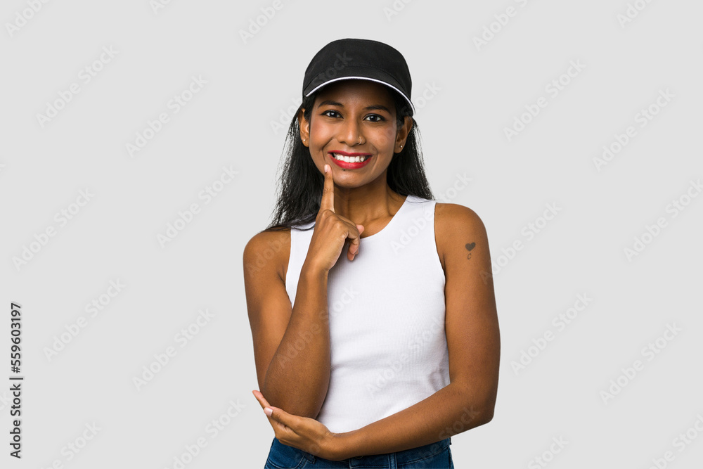 Young Indian woman cut out isolated on white background smiling happy and confident, touching chin with hand. Young Indian woman cut out isolated on white background smiling happy and confident, touching chin with hand.