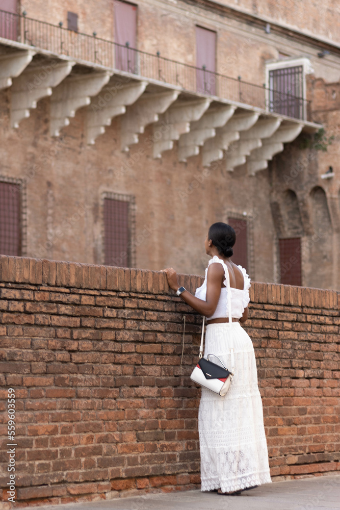 Portrait of turist woman dressed in white getting to know Europe, Ferrara. Italy