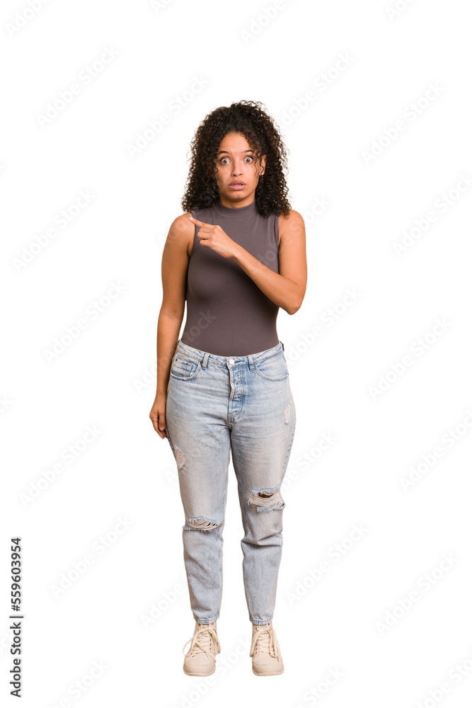 Young african american woman with curly hair cut out isolated pointing to the side