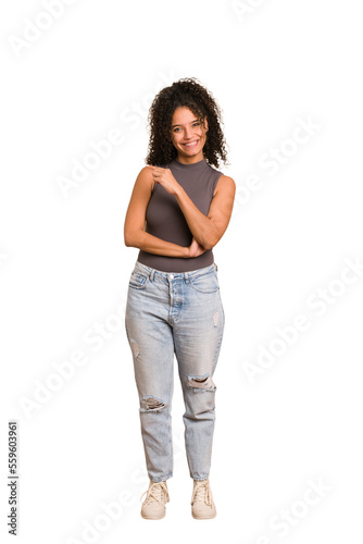 Young african american woman with curly hair cut out isolated smiling cheerfully pointing with forefinger away.