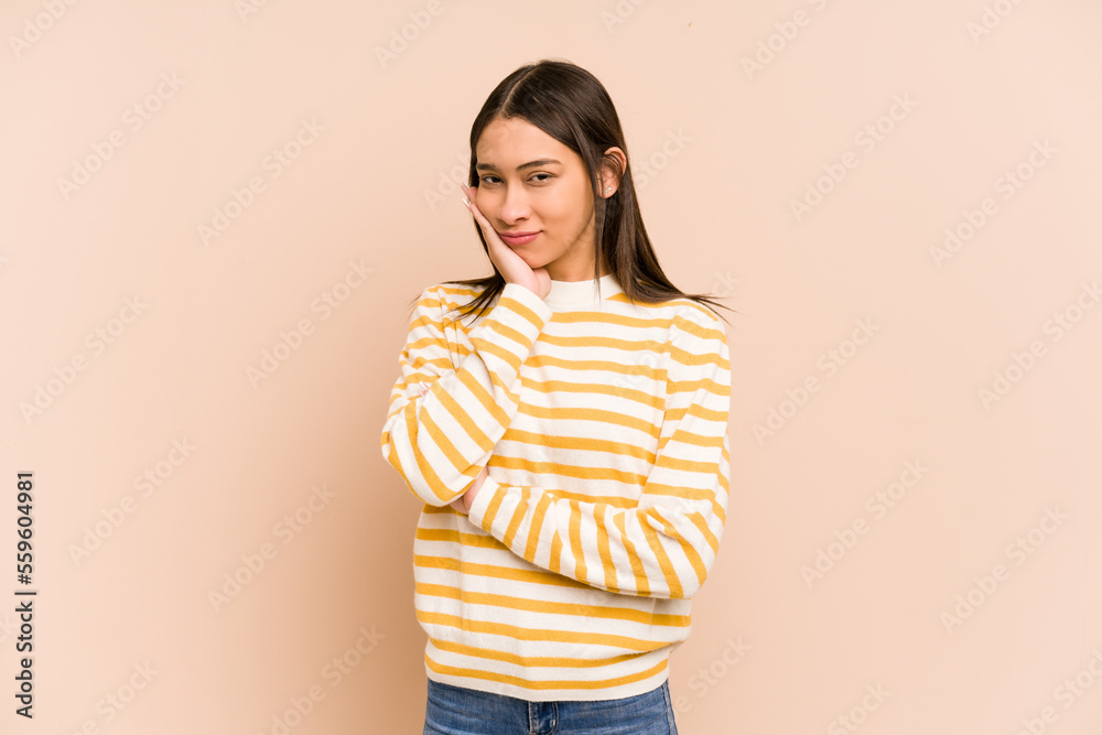 Young colombian woman isolated on beige background who is bored, fatigued and need a relax day. Young colombian woman isolated on beige background who is bored, fatigued and need a relax day.