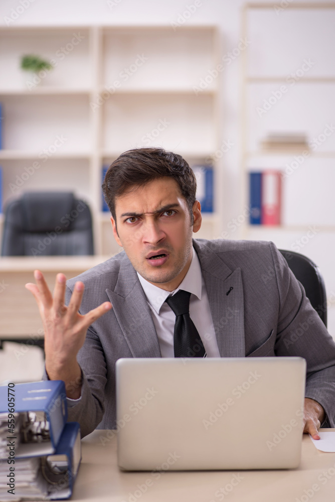 Young male employee working in the office Young male employee working in the office