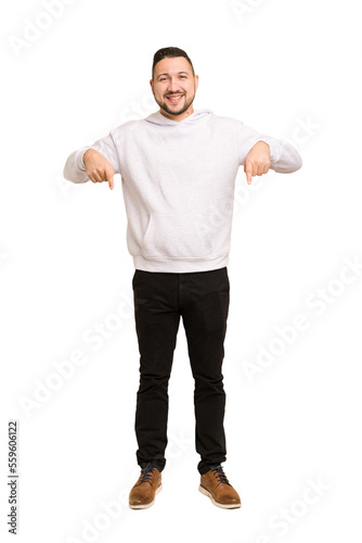 Full body adult latin man cut out isolated points down with fingers, positive feeling.