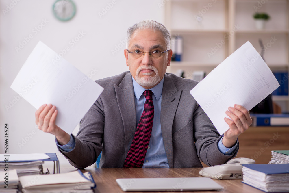 Old male boss employee working in the office Old male boss employee working in the office
