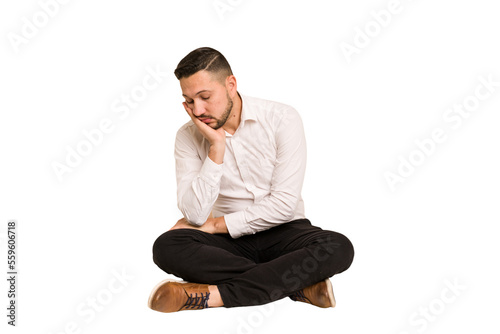 Adult latin man sitting on the floor cut out isolated who is bored, fatigued and need a relax day.