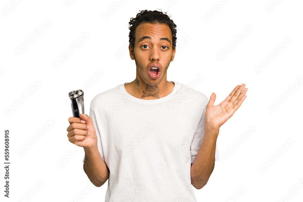 Young African American man holding a razor isolated surprised and shocked. Young African American man holding a razor isolated surprised and shocked.