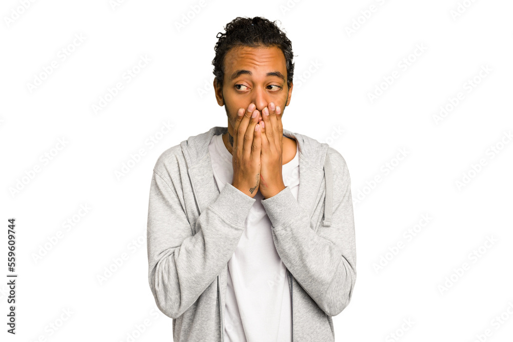Young African American man isolated thoughtful looking to a copy space covering mouth with hand. Young African American man isolated thoughtful looking to a copy space covering mouth with hand.