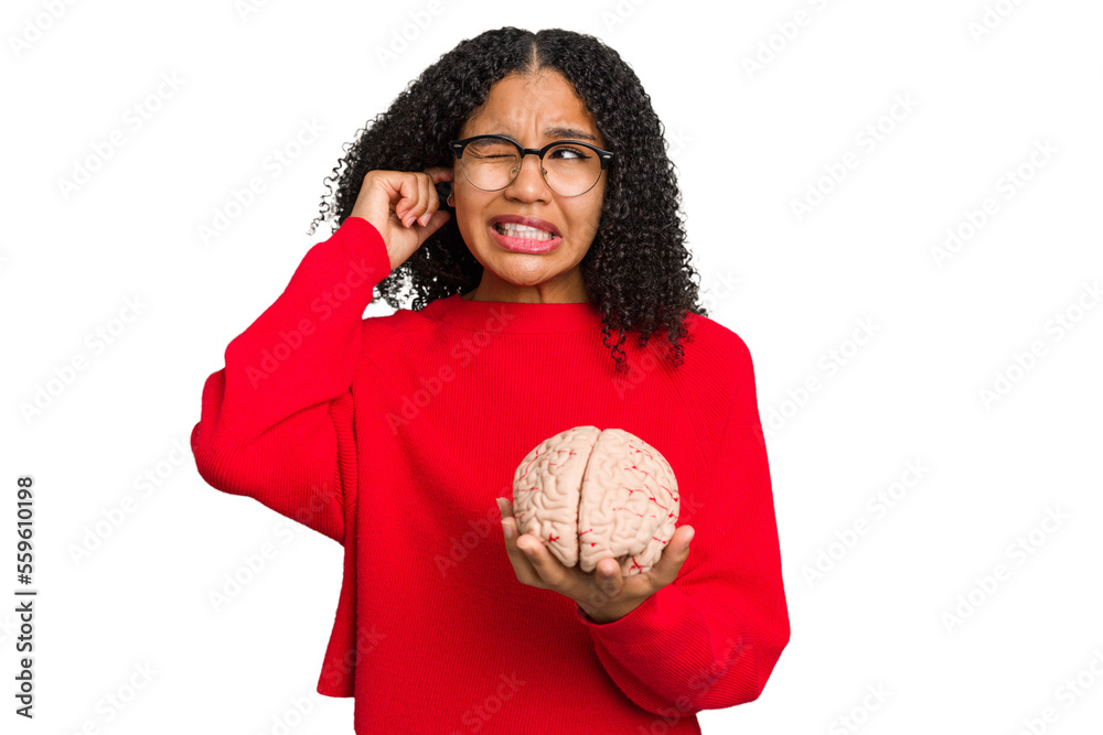 Young african american woman holding a brain model isolated covering ears with hands. Young african american woman holding a brain model isolated covering ears with hands.