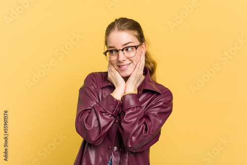 Young caucasian redhead woman isolated on yellow background scared and afraid.