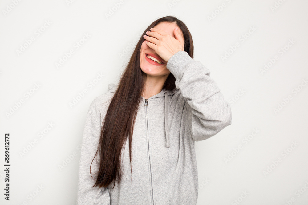 Young caucasian woman isolated on white background laughs joyfully keeping hands on head. Happiness concept. Young caucasian woman isolated on white background laughs joyfully keeping hands on head. Happiness concept.