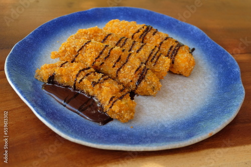 Crispy fried banana sprinkled with melted chocolate.