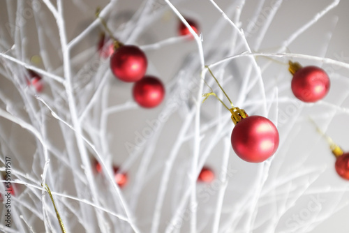 Close-up of red Christmas baubles decorated on white branches at home photo