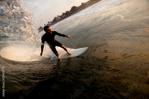 A male surfer sets up for a barrel while surfing the notorious beach break of Pasquales, Mexico. photo