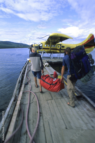 Wallpaper Mural Blur motion shot of two men hauling a loaded duffel bag to a waiting floatplane. Torontodigital.ca
