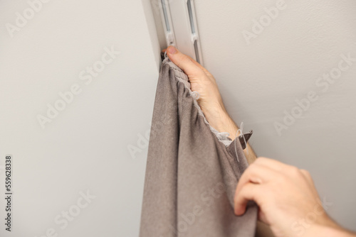 Worker hanging window curtain, low angle view. Space for text