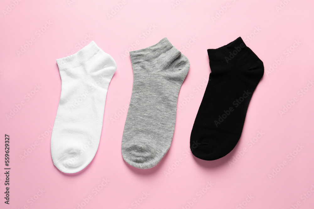 Different socks on pink background, flat lay Different socks on pink background, flat lay