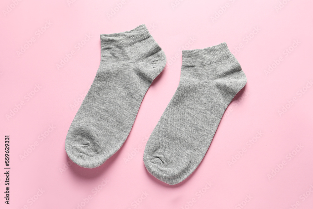 Pair of grey socks on pink background, flat lay Pair of grey socks on pink background, flat lay