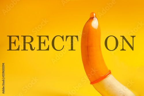 sexualized banana with yellow condom on yellow background, penis symbol in contraceptive, good erection photo