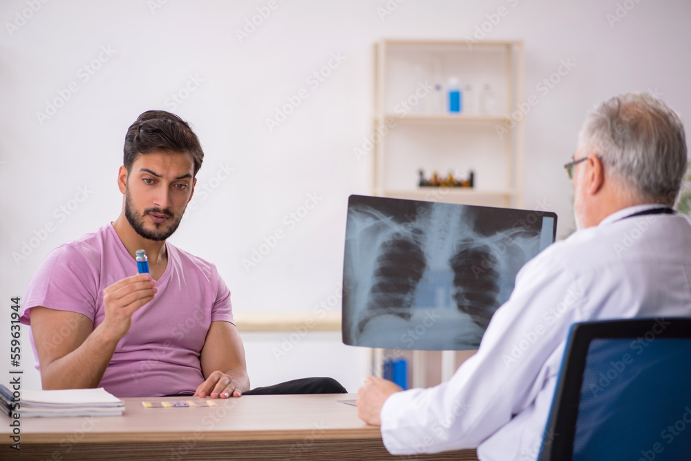 Obraz premium Young male patient visiting old male doctor radiologist
