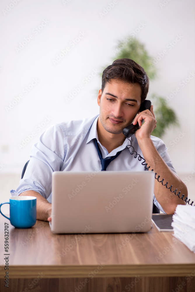 Young male employee working in the office Young male employee working in the office