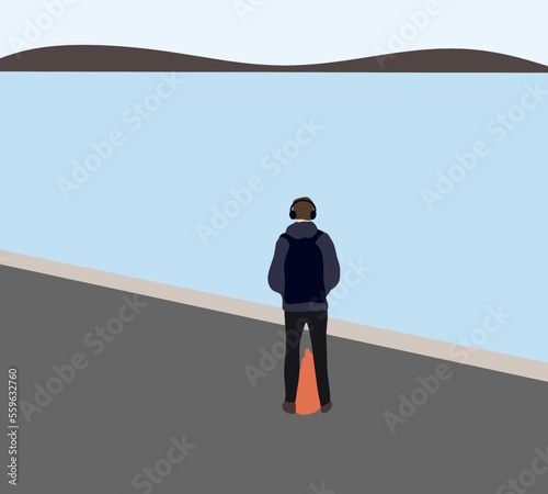 Man with headphone listens to music standing near river. Relaxation and resting concept